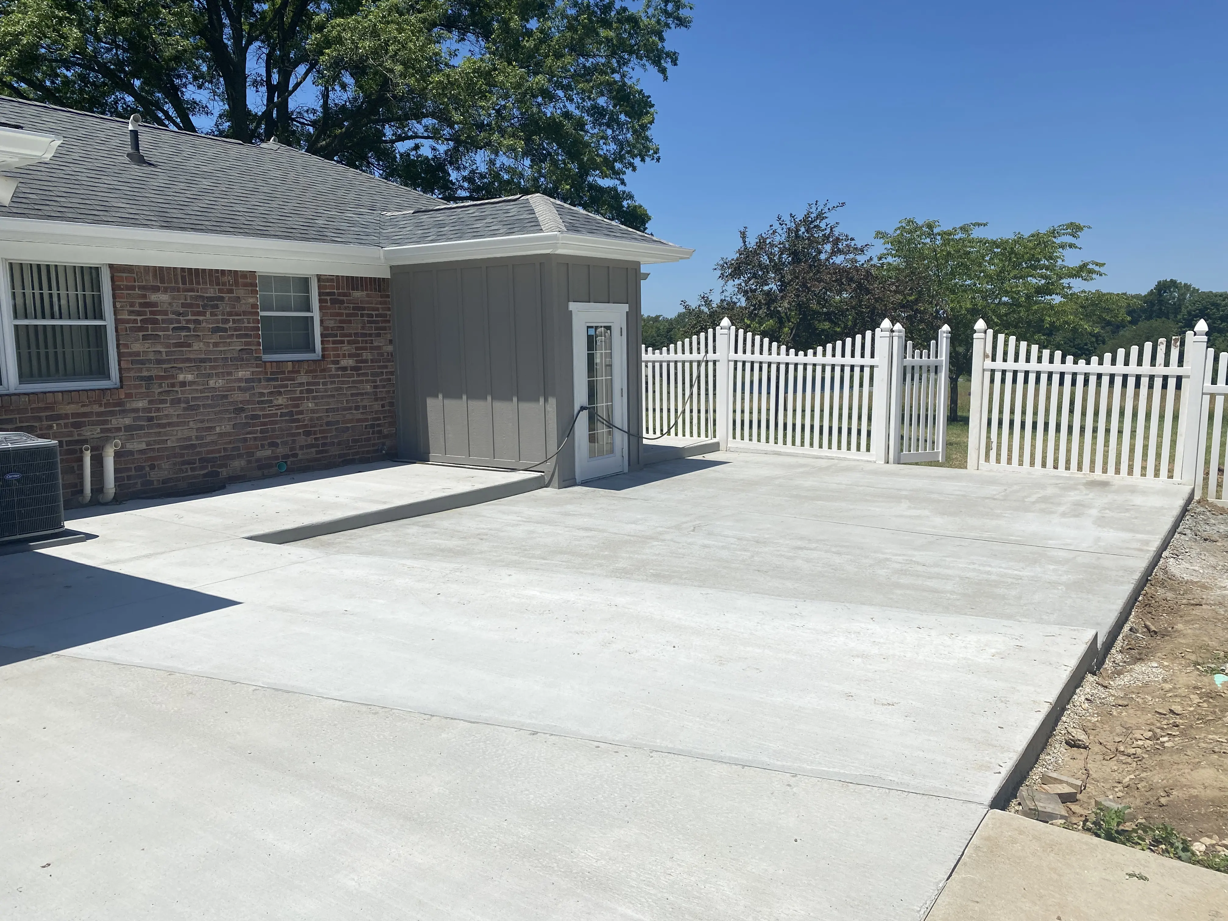 Concrete patio with white picket fence